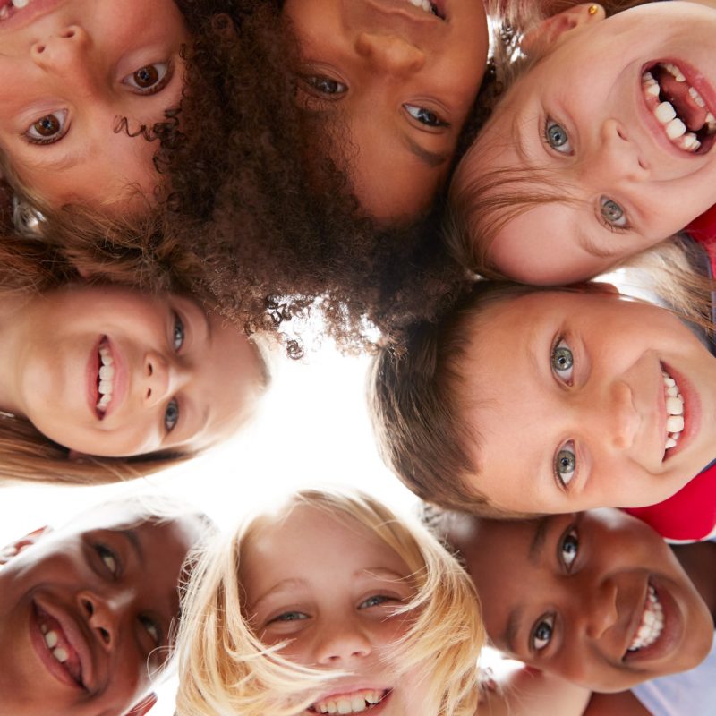 Group Of Multi-Cultural Children With Friends Looking Down Into Camera
